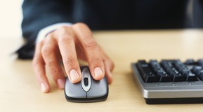 Mans hand on computer mouse.